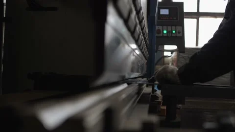 A bending machine operator bends a sheet metal workpiece on a CNC machine. Stock Footage 150736498
