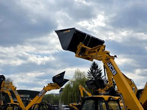 Beneath the Cloudy Sky JCB Bucket Loaders Stand Ready for Action in the Yard Stock Photos