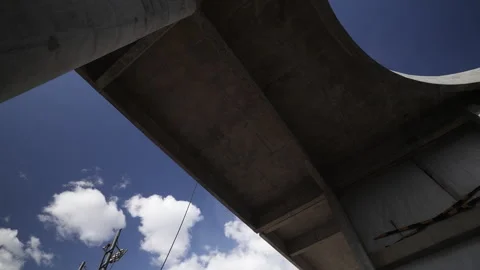 Beneath a Contemporary Concrete Overpass Beneath a Clear Blue Sky Above Stock Footage 305740326