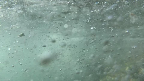 Beneath the surface flowing water moves dense air bubbles through seawater in na Stock Footage 344850026
