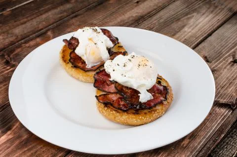 Benedict eggs with crispy bacon and hollandaise sauce on toasted maffin Stock Photos