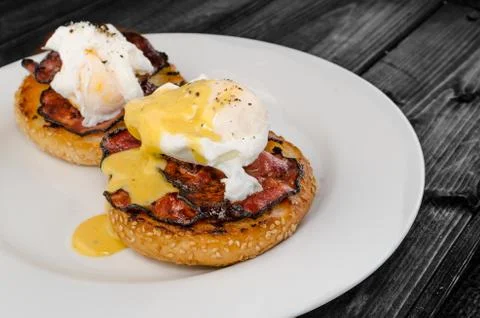 Benedict eggs with crispy bacon and hollandaise sauce on toasted maffin Stock Photos