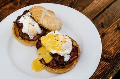 Benedict eggs with crispy bacon and hollandaise sauce on toasted maffin Stock Photos