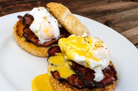 Benedict eggs with crispy bacon and hollandaise sauce on toasted maffin Stock Photos