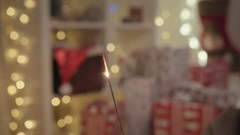 Bengal lights are burning in front of Christmas decorations. Stockbeeldmateriaal 230181760
