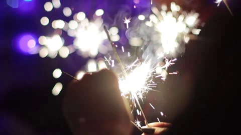 Bengal lights in hands against the background of New Years lights on Christmas Stock Footage 293683082