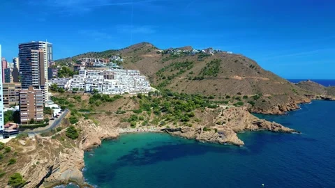 Benidorm in Spain over flight by drone from behind the hill scyscrappers Stock Footage 214367504