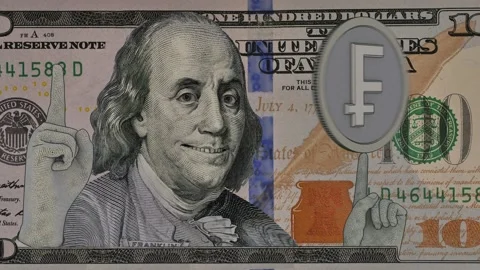 Benjamin Franklin on a hundred dollar bill slips a Swiss franc coin on his fi Stock Footage 202290569