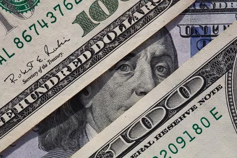 Benjamin Franklin peeking through 100 dollar banknotes Stock Photos