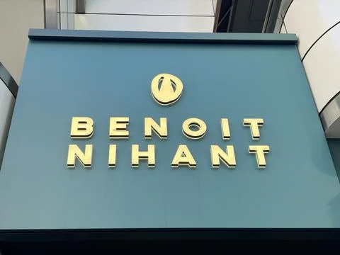 Benoit Nihant chocolatier shop sign featuring golden 3D lettering on a teal.. Stock Photos