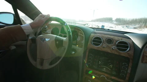 Bentley steering wheel and panel. A man drives his bentley car along the road Stock Footage 148513607