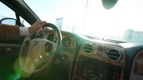 Bentley steering wheel and panel. A man drives his bentley car along the road Stock Footage 148513789