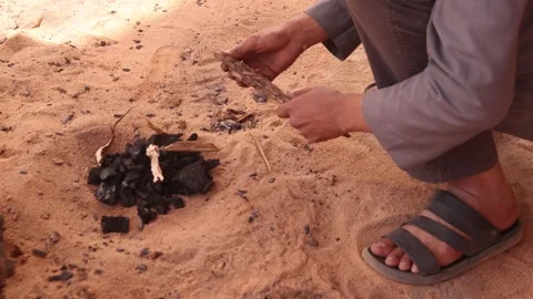Berber indigenous tribes people preparing fire in to the Sahara desert survival Stock Footage 303573507