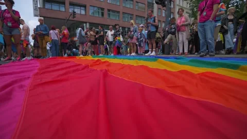Berlin - 22.07.2023. Long pride flag on city street before parade Stock Footage 323461550