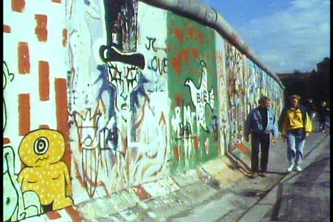Berlin, The Berlin Wall in 1988, people walk alongside, graffiti Stock Footage