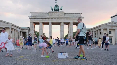 Berlin Brandenburg gate sightseeing man makes big soap bubbles entertaining Stock Footage 138297660