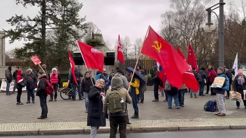 Berlin: Communist sympathiser waves Soviet flag during demo at War Memorial, 4K Stock Footage 256472496