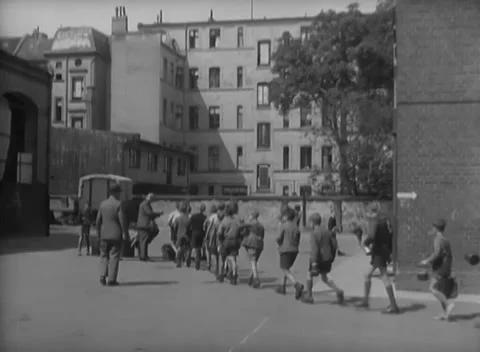BERLIN, GERMANY - 1946: Children's queue - Boys carry tins across damaged yard Video stock 344495684