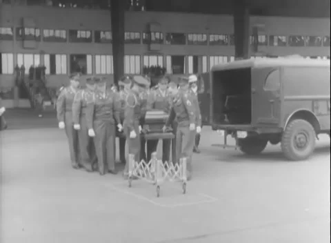 BERLIN, GERMANY - 1948: Hangar transfer - Pallbearers unload coffin in hangar Stock Footage 344494785