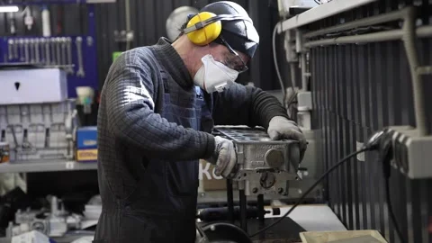 Berlin. Germany, CIRCA 2022. Engineer repairs a car engine in his garage wearing Stock Footage 194490370