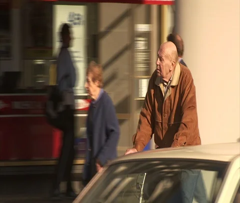 Berlin, Germany; Elderly man riding bicycle past shops Stock Footage 86742984