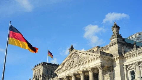 BERLIN GERMANY German flags fluttering in the wind and building of Reichstagin Stock Footage