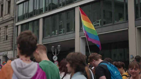 Berlin, Germany - July 26, 2025: A rainbow pride flag waves above participants Stock Footage 346239711