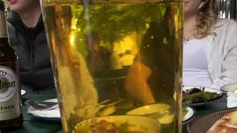 Berlin, Germany - May 23, 2026 - beer glass filled with amber liquid, reflecting Stock Footage 337191304