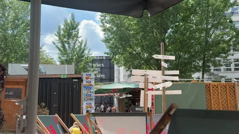 Berlin, Germany - May 23, 2026 - urban beach bar, relaxed casual outdoor cafe, Stock Footage 337662794