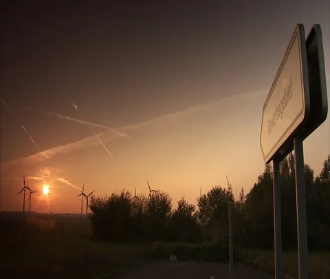 Berlin, Germany; wind turbines slowly turning with amber sky Stock Footage 86743229