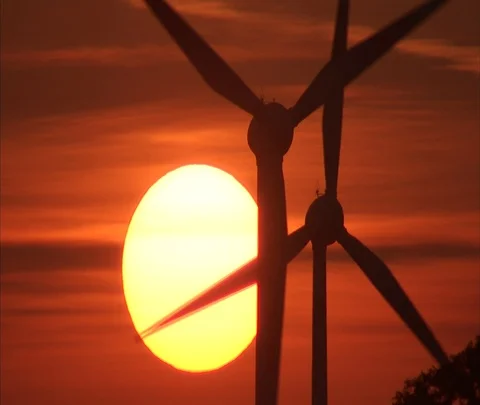 Berlin, Germany; wind turbines slowly turning with big sun in orange sky Stock Footage 86743294