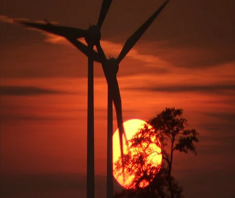 Berlin, Germany; wind turbines slowly turning with setting sun and orange sky Stock Footage 86743320