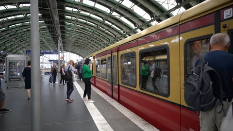 Berlin - Train arrives at the S-Bahn station, with travelers getting on and off Stock Footage 114073351