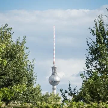 Berlin TV Tower framed by green trees, summer sky, Germany Fotos de archivo