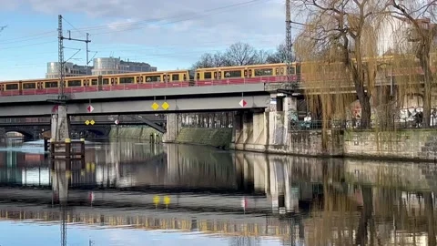 Berlin: Two rapid transit railway commuter trains (S-Bahn) cross Spree River, 4K Stock Footage 169091021