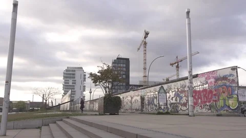 Berlin wall with city and cloudy sky backdrop Stock Footage 74165964