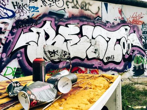 Berlin wall in germany with graffiti with empty spray can bottles Stock Photos