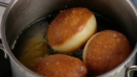 Berliners. Rolling donuts in oil. Donuts are fried in vegetable oil. Delicious Stock Footage 152484951