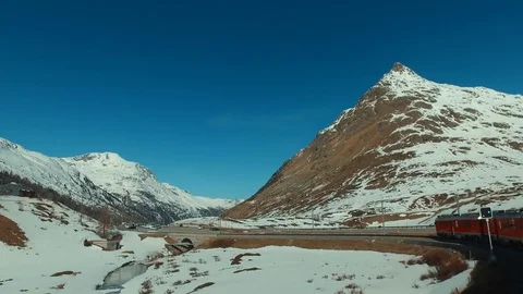 Bernina Express red train ascends to the Bernina Pass, glacier and Diavolezza Video stock 74063380