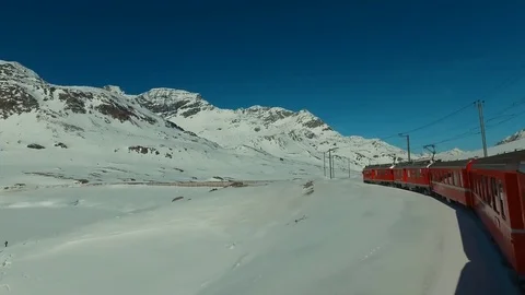 Bernina Express red train ascends to the Bernina Pass, glacier and Piz Bernina Stock Footage 74063417