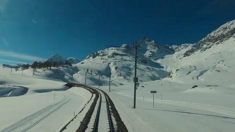 Bernina Express red train ascends to the Bernina Pass, glacier and Piz Bernina Stock Footage 74063420