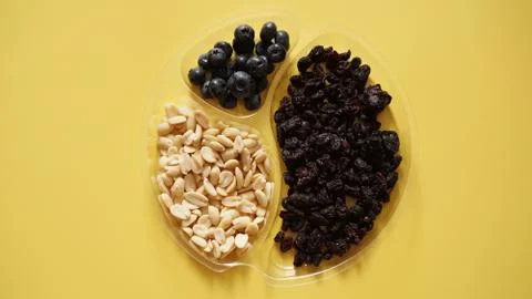 Berries ad nuts in plastic container for food storage Stock Photos