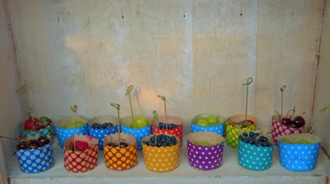 The berries are in the colored cups, grapes, strawberries, cherries Stock Footage 65421780