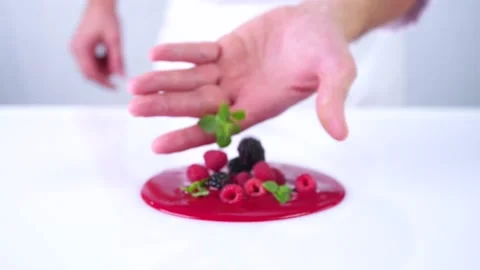 The berries are falling from the hand to the red sauce. Stock Footage 130852736