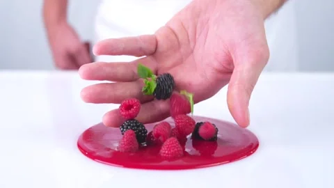 The berries are falling from the hand to the red sauce. Stock Footage 141522957
