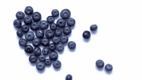 The berries are rolling towards the blueberry heart on white background. Stock Footage 160224124