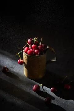 Berries of a cherry on branches in a bucket, rustic. Female hands hold branches. Stock Photos