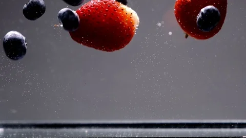 Berries fall into water isolated on white in slow motion. Stock Footage 126060927