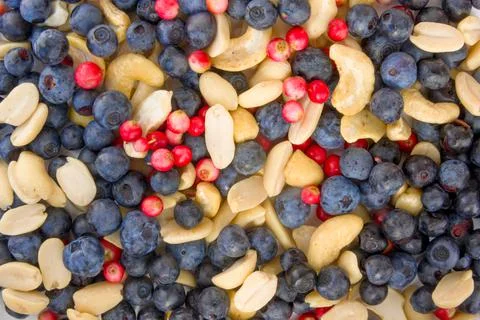 Berries, nuts food pattern of Peanuts, cashews, blueberries, lingonberries Stock Photos
