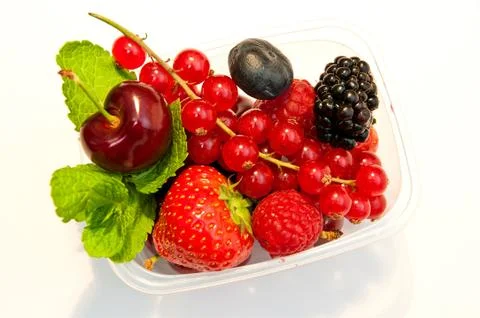 Berries in a plastic box on a white background Stock Photos